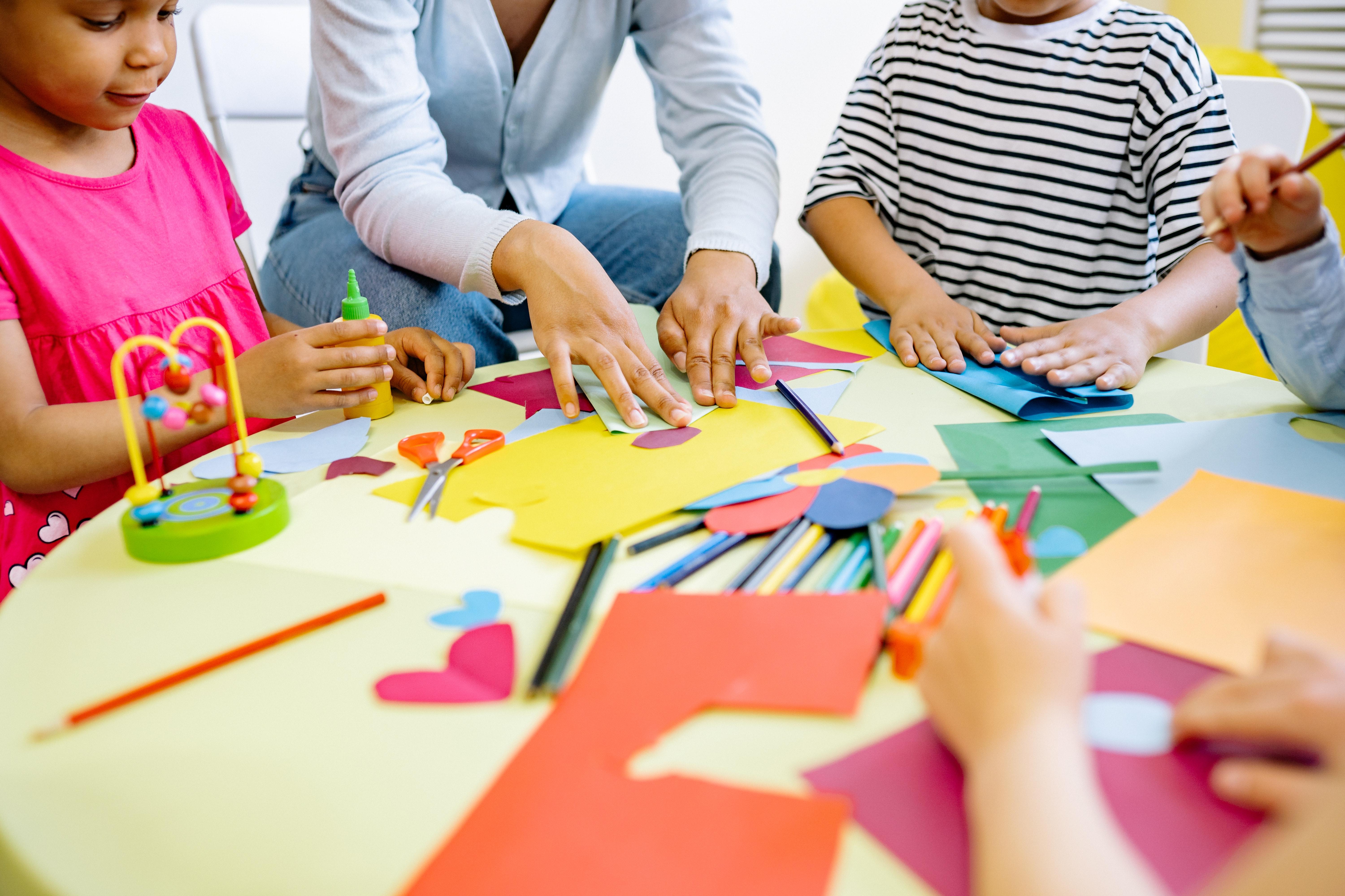 Small children doing arts and crafts with their teacher